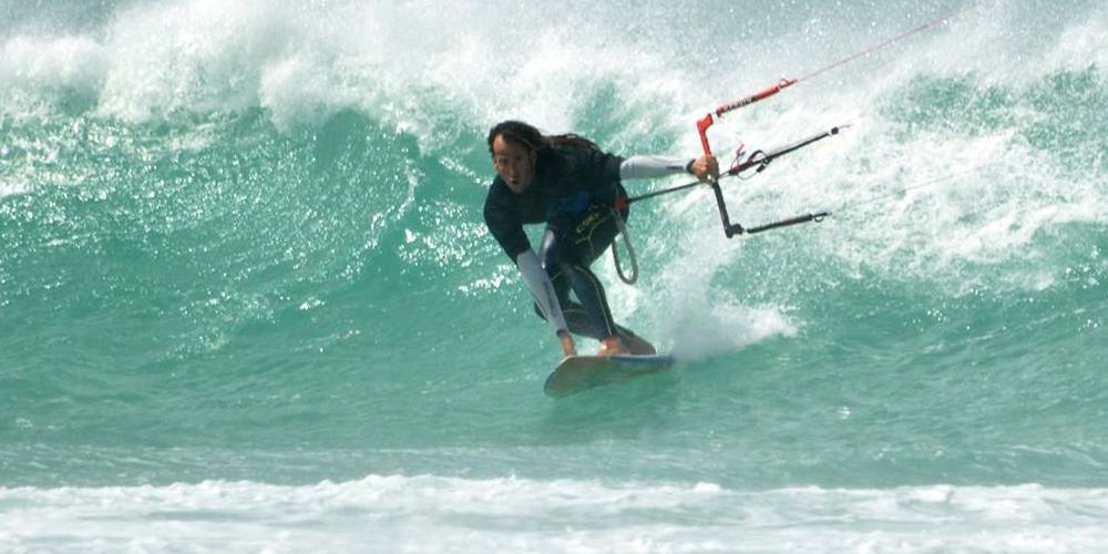 Lucas en una ola con kitesurf