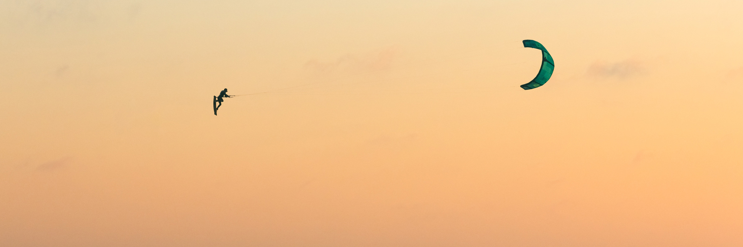 Kiter volando por los aires al atardecer
