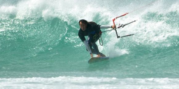 Lucas en una ola con kitesurf