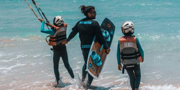 Monitor de kitesurf con niño en playa