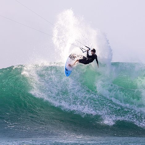 Chico surfeando en una ola con el kitesurf