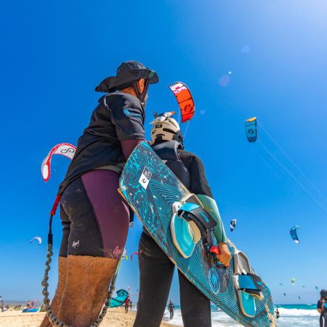 Chica levantando cometa en la orilla del Mar en Tarifa